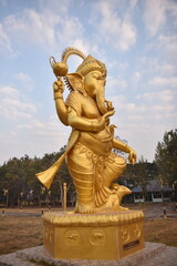 Obraz premium Statue of Lord Ganesha standing and giving blessings. A beautiful golden color rich in history and religion.