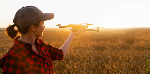 Woman farmer with drone on a wheat field. Smart farming and precision agriculture.