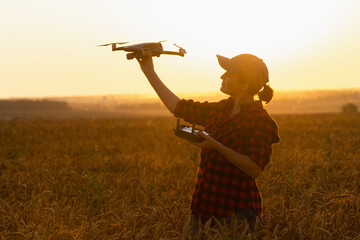 Woman farmer with drone on a wheat field. Smart farming and precision agriculture