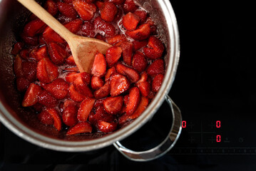 Making sweet strawberry jam in kitchen. Summer food concept. Top view