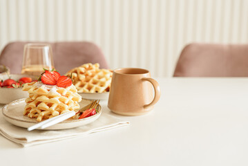 Belgian waffles with strawberries and powdered sugar on white table. Summer food concept. Soft focus