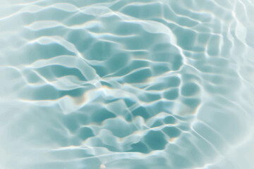 Blue water with ripples on the surface. Defocus blurred transparent blue colored clear calm water surface texture with splashes and bubbles. Water waves with shining pattern texture background.