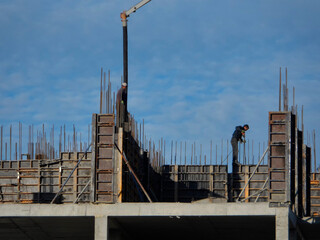 Modern building under construction. Construction details - worker laying and pouring cement or concrete with automatic pump. Concrete pump. Formworking. Ust-Kamenogorsk (kazakhstan)