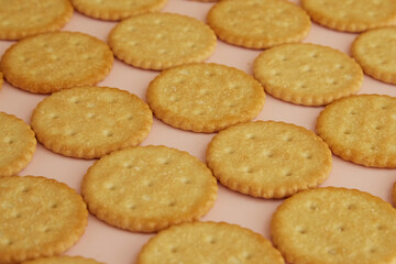 Salty crackers on a pink background close-up, cookies on a pink background, cookies on the table
