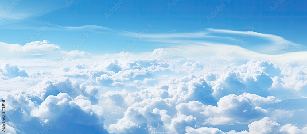 Poster wonderful view from the airplane window flying above the clouds cumulus clouds with blue sky in sunn