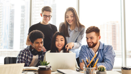 A collaborative scene unfolds in the library where multiracial students use various devices to study. The environment is calm, with a focus on shared knowledge and technology.