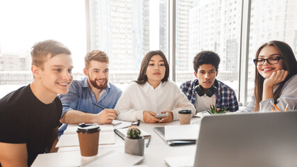 Skilled young programmers watching webinar about software development on laptop computer