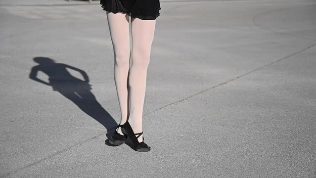 Ballerina dancing outdoors. Close-up of a woman's legs in Czech shoes.