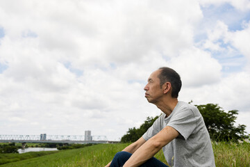 河川敷に座る中高年男性