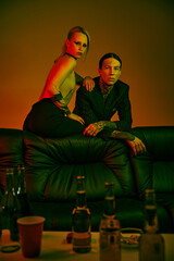 Man and woman relaxed on a couch at a lively rave party