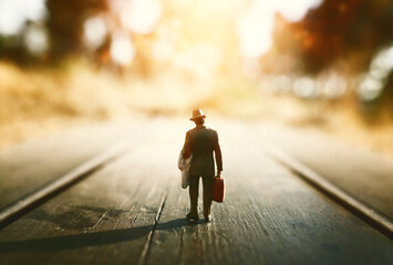 Concept image of lonely figure walking in sunset towards the horizon
