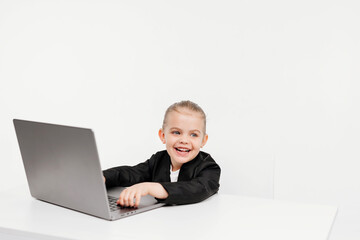 Close-up of a stylish business girl child studying at a laptop on an isolated white background. The concept of modern technology, business and education.