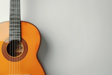 Obraz premium A Classical Acoustic Guitar Leans Against a White Wall in a Studio Setting