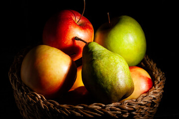 apple pear basket on black background