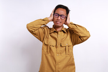 Stressed young indonesian government staff covering ears and screaming