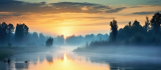 Fototapeta premium Summer river landscape sunset fog view The sun goes down the horizon. Creative banner. Copyspace image