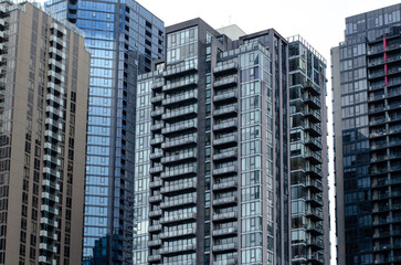Obraz premium High-rise modern residential apartment buildings with glass facades are clustered together, creating a high-density urban living community. Southbank, Melbourne VIC Australia.