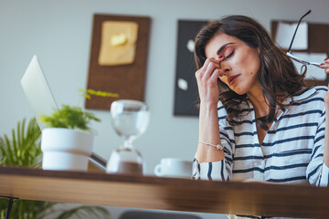 A professional Caucasian woman delves deep into strategizing, her gaze fixed on the laptop screen in an office setting, reflecting thoughtful decision-making.