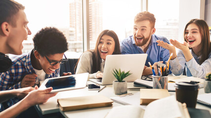 Multiethnic friends having fun, studying together for exams in library