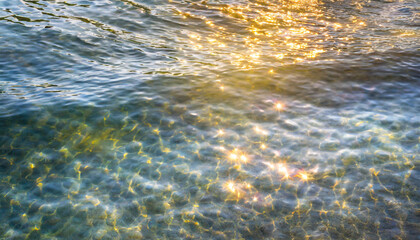 water waves of the sea and ocean with glare and rays of the sun, summer wallpaper for the presentation of recreation and vacation