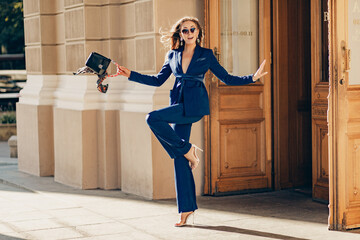 elegant attractive woman wearing blue stylish suit walking in street