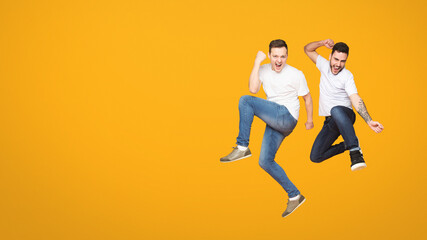 Duo of european men captured mid-jump against orange backdrop, encapsulating the essence of...