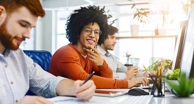 Work at IT company, friendly black guy smiling at camera at coworking space, panorama
