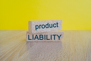 PRODUCT LIABILITY - words on brick blocks on wooden table, yellow background. Business and PRODUCT...