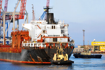 Tugboat assisting bulk cargo ship