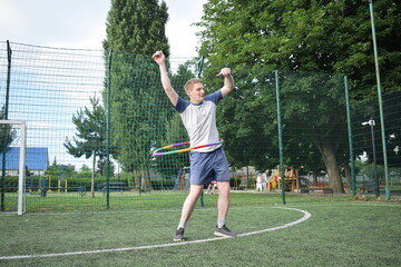 A young man in sportswear engages in a workout, using a sport tool for physical exercises on a sports field in the morning. His dedication to fitness performs training routine with focus and energy
