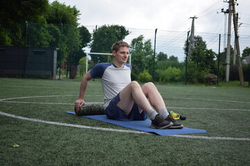 A young man in sportswear engages in a workout, using a sport tool for physical exercises on a...
