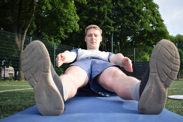 A young man in sportswear engages in a workout, using a sport tool for physical exercises on a...