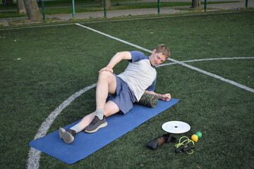 A young man in sportswear engages in a workout, using a sport tool for physical exercises on a...