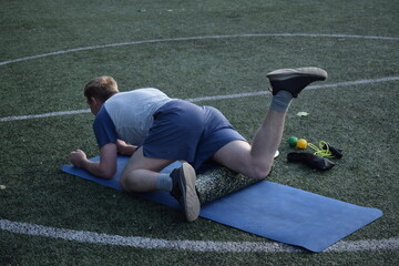 A young man in sportswear engages in a workout, using a sport tool for physical exercises on a...