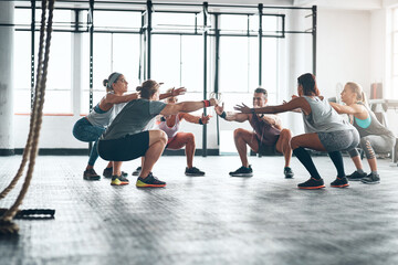 People, squating and workout together in gym for body wellness, group and exercise for leg strength. Balance, determination and core power or abdominal training or calves, challenge for fitness class