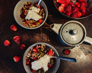 Healthy breakfast. Fresh granola, muesli with yogurt and berries on marble background. Top view.