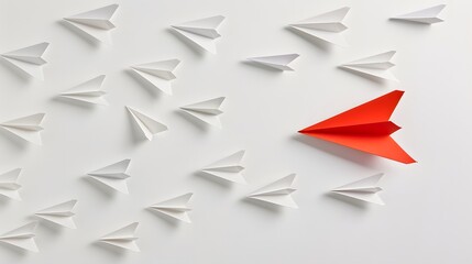 Paper airplanes on a plain white backdrop, with a single red airplane ahead, representing leadership and distinction