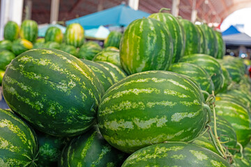 Watermelons on the stall of a watermelon seller in the market.