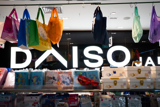 SINGAPORE - APRIL 19, 2022: Daiso logo illuminated inside the store, surrounded by products.