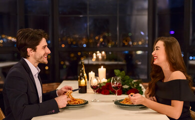 Loving beautiful young couple in a restaurant celebrating anniversary. Romantic dinner on Valentine day concept