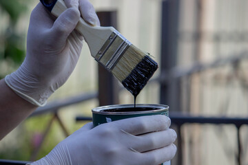close-up of a hand painting a metal pipe. Selective focus