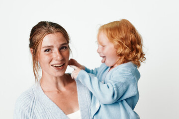 Happy mother and daughter smiling together against white background holding handstravel beauty lifestyle portrait concept