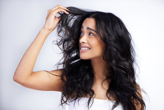 Frustrated, woman and hair loss in studio for care, crisis and unhappy with treatment. Model girl, thinking and stress for texture, split ends and confused or upset for damage by white background