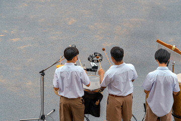 Group of Asian students in uniform perform a orchestra band in festival performance at stadium....