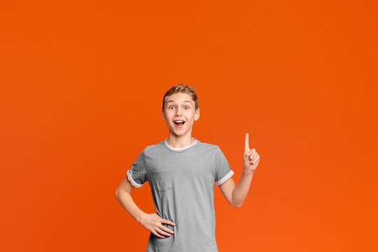 Great Idea. Excited Positive Boy Got Solution For Problem, Gesturing Finger Up, Orange Background With Free Space