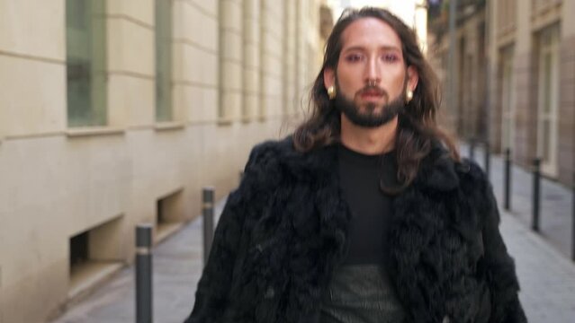 Queer man walking in the street looking to camera with attitude . Gay LGBT people