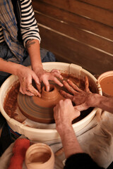 Potter teaching woman to craft ceramic jug on a pottery wheel