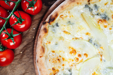 A delicious pizza topped with melted cheese and slices of pear, presented on a wooden board