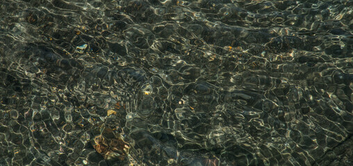 fondo de agua de con iluminación natural y piedras al fondo 