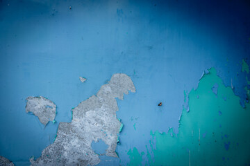 A blue and green wall with a crack in it